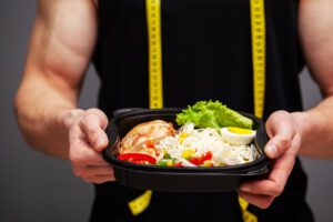 Closeup of a man holding a box full of protein rich foods for sports nutrition